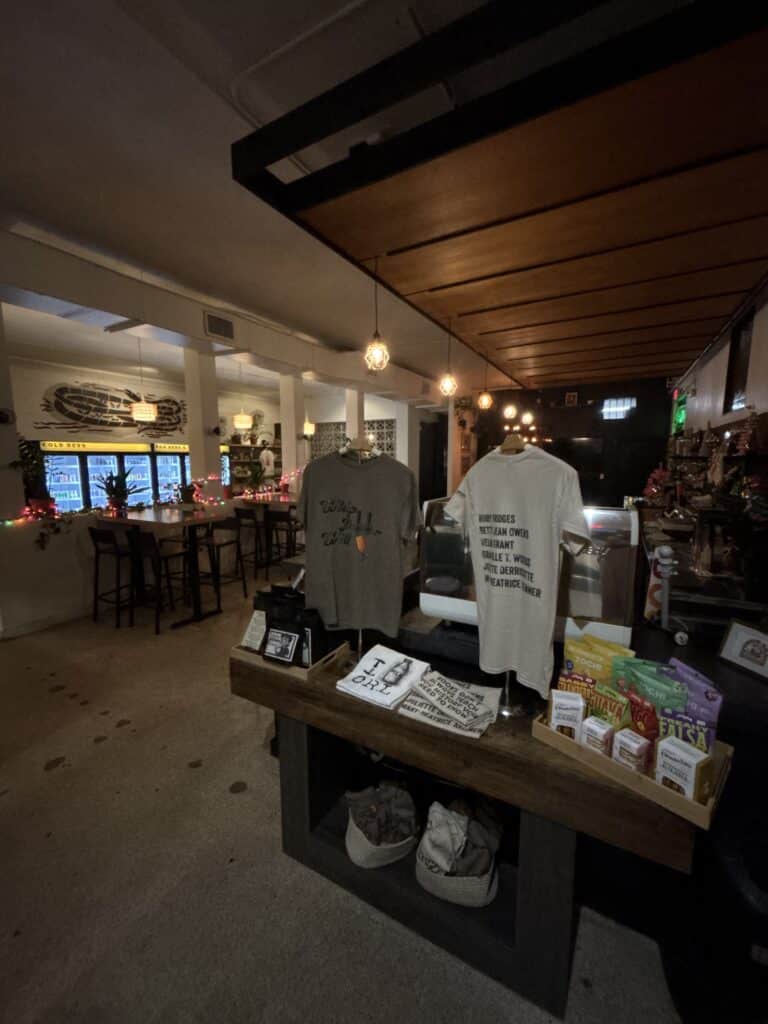 Retail display with shirts, books, and goods inside BookBurn Café and Social in Orlando.