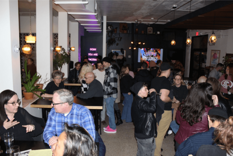 BookBurn Cafe and Social's grand opening showing a crowd of happy people inside.