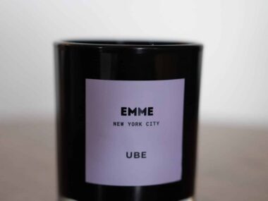 EMME New York City Ube candle in a black glass jar displayed on a table at BookBurn Cafe and Social