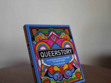 QueerStory infographic history of the fight for LGBTQ+ rights book displayed on a table at BookBurn Cafe and Social
