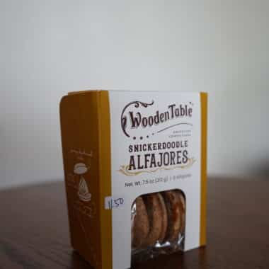 Wooden Table Snickerdoodle Alfajores cookie box displayed on a table at BookBurn Cafe and Social