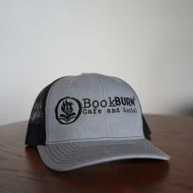 Gray and black BookBurn logo hat displayed at BookBurn Cafe in Orlando