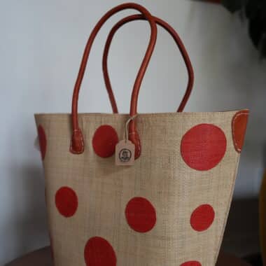 BookBurn polka dot tote bag with red handles displayed inside BookBurn Cafe in Orlando