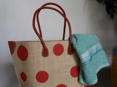BookBurn polka dot tote bag with red handles displayed inside BookBurn Cafe in Orlando with towel hanging out of the top of the bag.