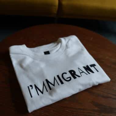 Immigrant’ statement t-shirt folded on a table inside BookBurn Cafe in Orlando
