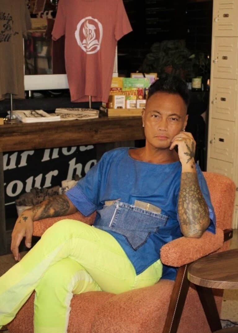 Jonny Cruz, owner of BookBurn Cafe and Social in Orlando, seated inside the cafe surrounded by merchandise and books