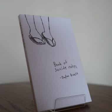 Book of Suicide Notes by Dayton Bissett displayed on a table at BookBurn Cafe and Social