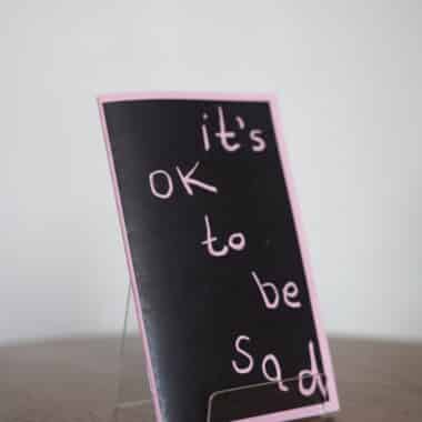 It’s OK to Be Sad card displayed on a table at BookBurn Cafe and Social