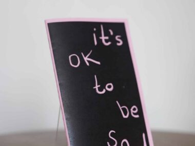 It’s OK to Be Sad card displayed on a table at BookBurn Cafe and Social